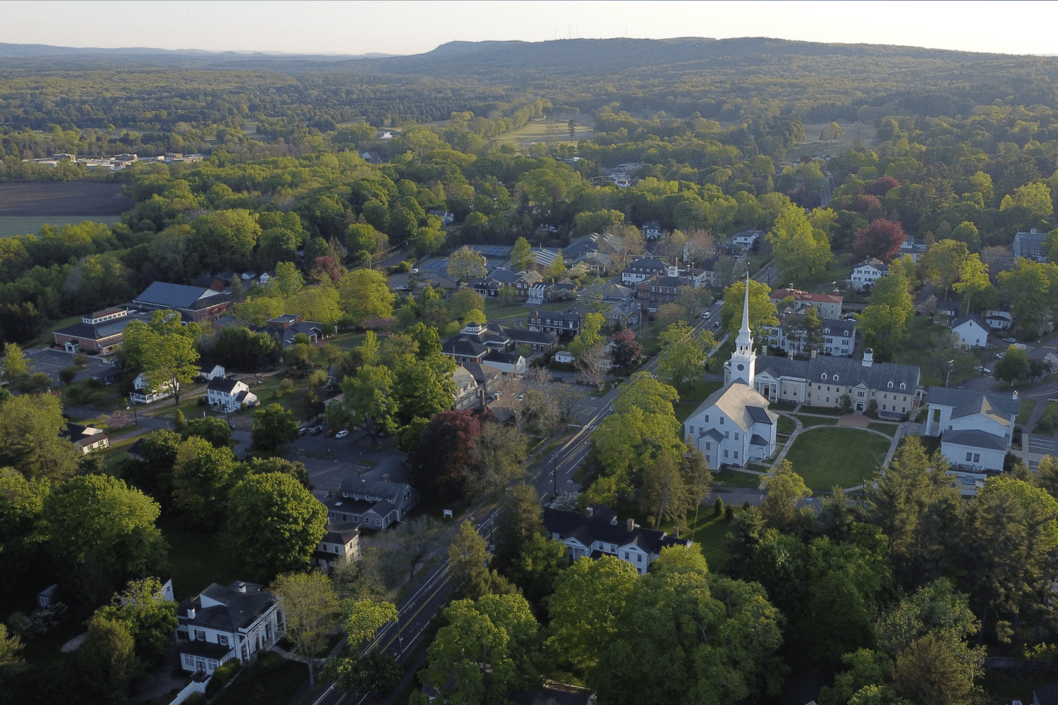 Farmington,_Connecticut Aerial drone view of Farmington, CT showcasing tree-lined streets, residential homes, and scenic landscapes.